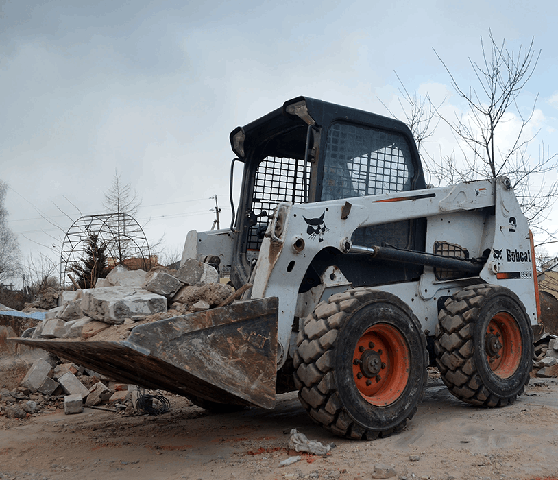 Skid steer hauling concrete debris